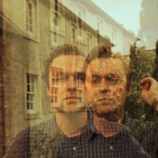 Joshua Burnside wearing a blue check shirt and gold watch